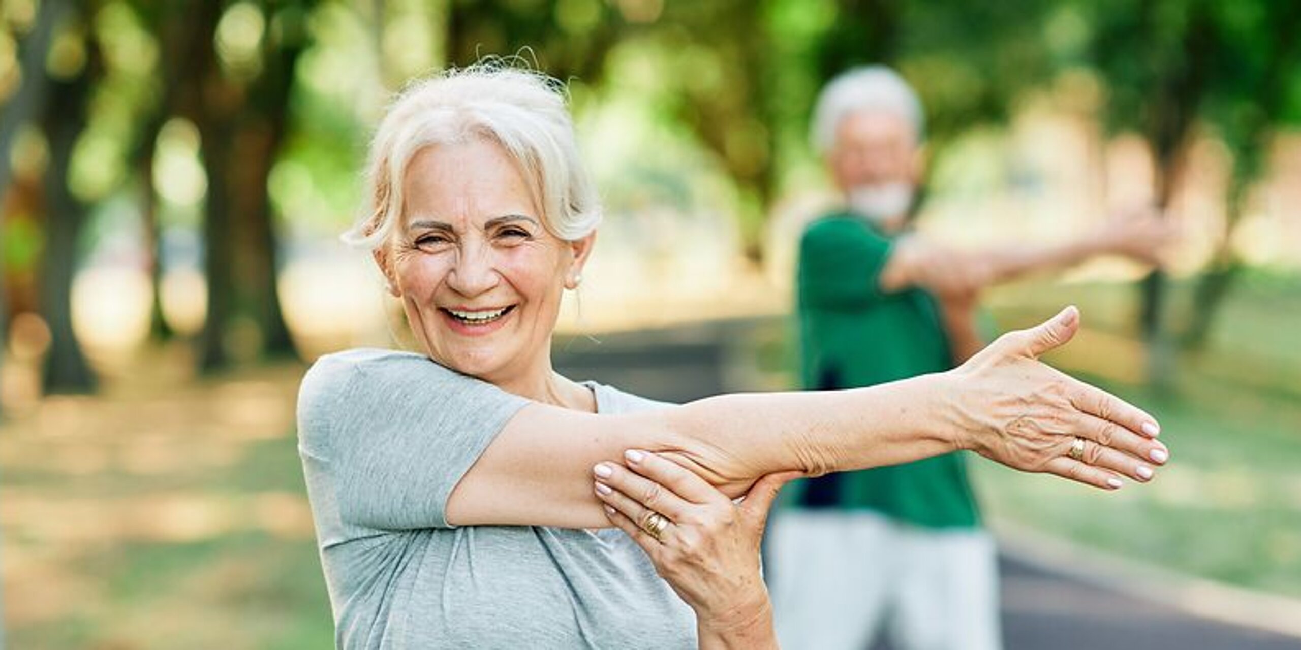 Patientin Gymnastik im Park Frau macht Dehnübungen im Park.